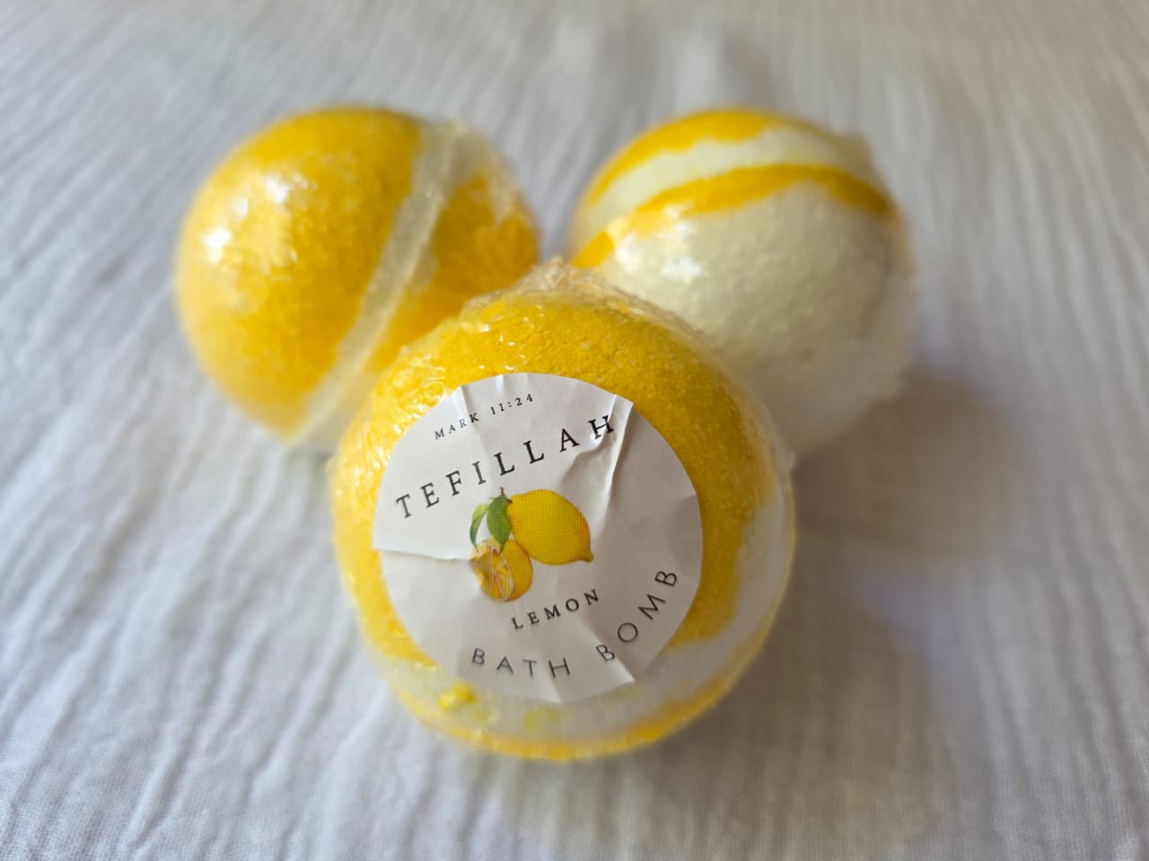Handmade lemon bath bomb by Tefillah Handmade Products, infused with lemon essential oil and coconut oil for an uplifting, mood-boosting bath experience